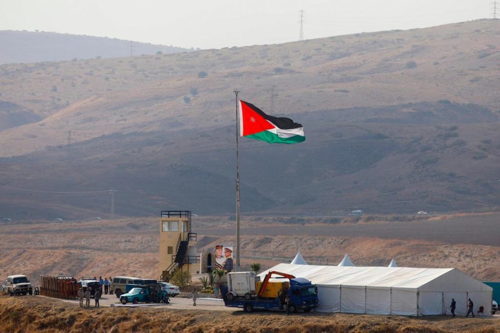 The Jordanian flag raised over a hastily constructed tent in the middle of an alfalfa field. Note the picture of Abdullah at the base of the flag.