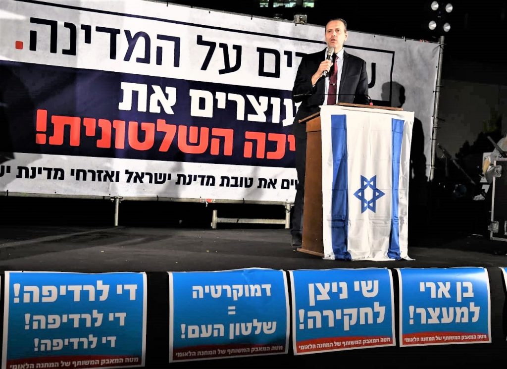 The large sign behind the speaker reads that we should keep the country together. The smaller signs in front about say that we should investigate the investigators and that democracy comes from people power.