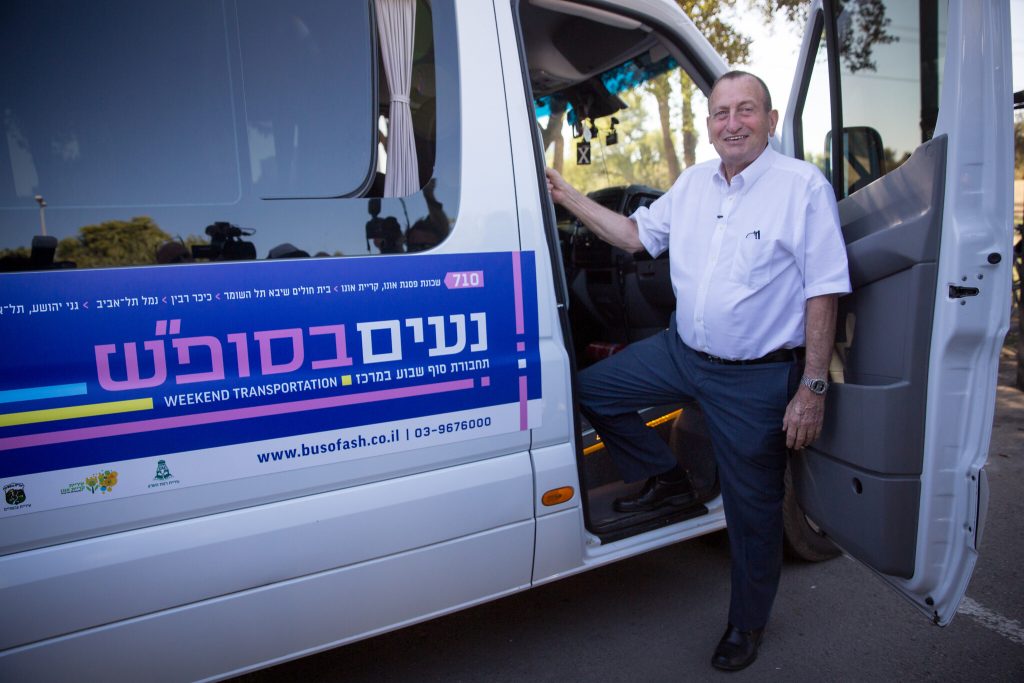 Proudly breaking Shabbat, Mayor of Tel Aviv Ron Huldai poses with one of the new Shabbat buses (photo: Times of Israel).