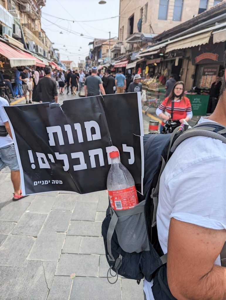 The sign on the man's backpack reads "Death To Terrorists!"