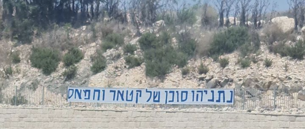 The sign reads that Netanyahu is an agent of Hamas and Qatar.